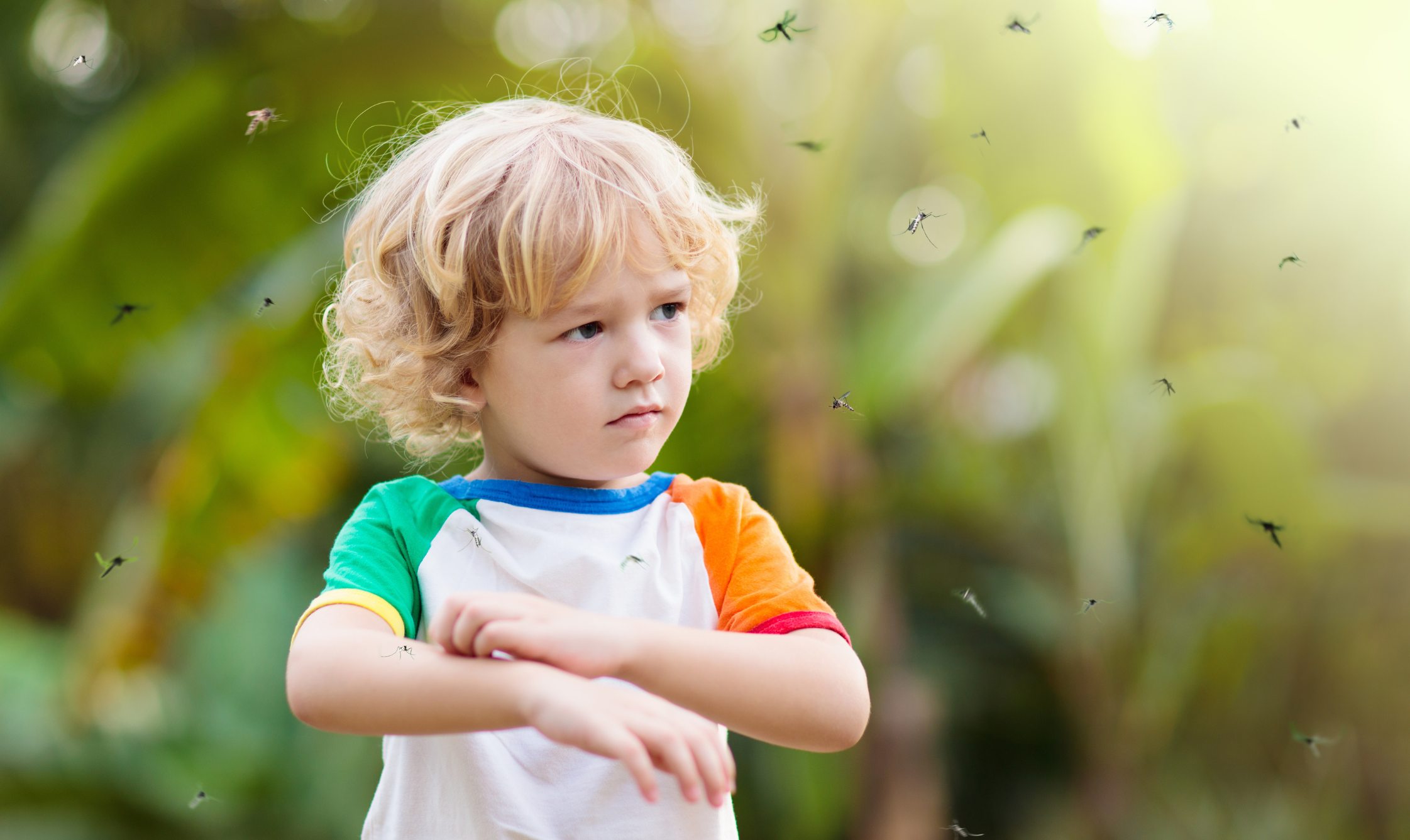 Little boy outside scratching from mosquitoes